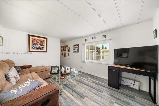 a living room with furniture a flat screen tv and a window