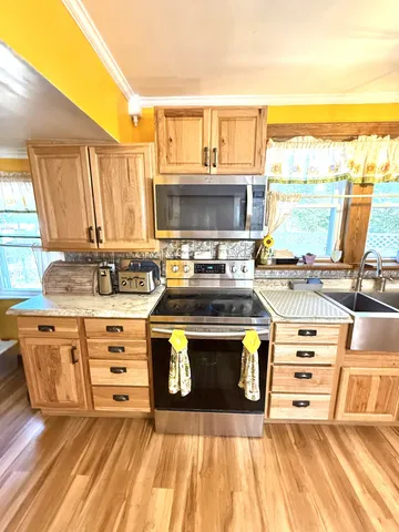 a kitchen with stainless steel appliances a stove a sink and a microwave