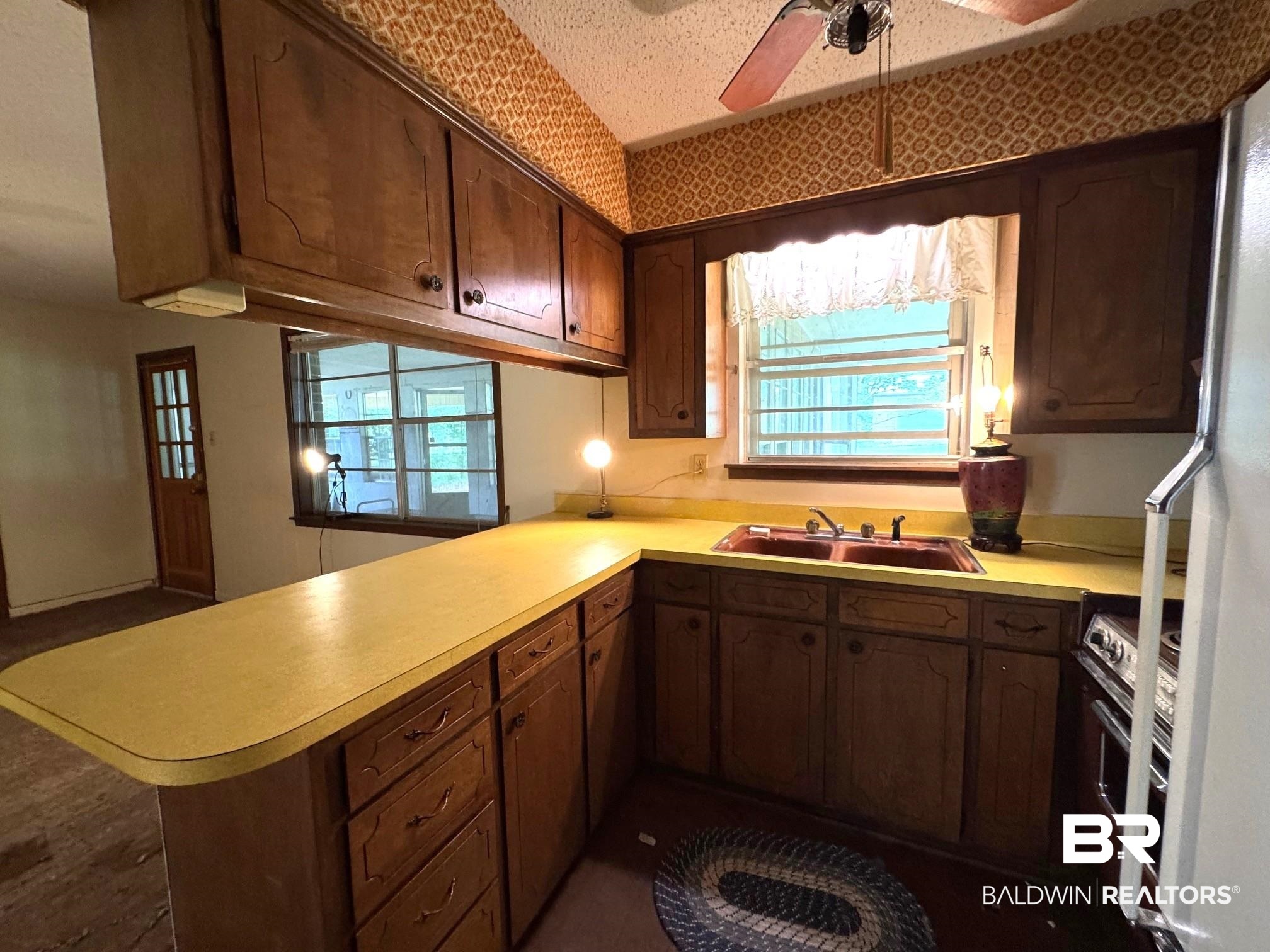 5198 Lancelot Drive Mobile, AL 36619 - Photo 6 of 30 Kitchen with a peninsula, healthy amount of natural light, ceiling fan, and light countertops