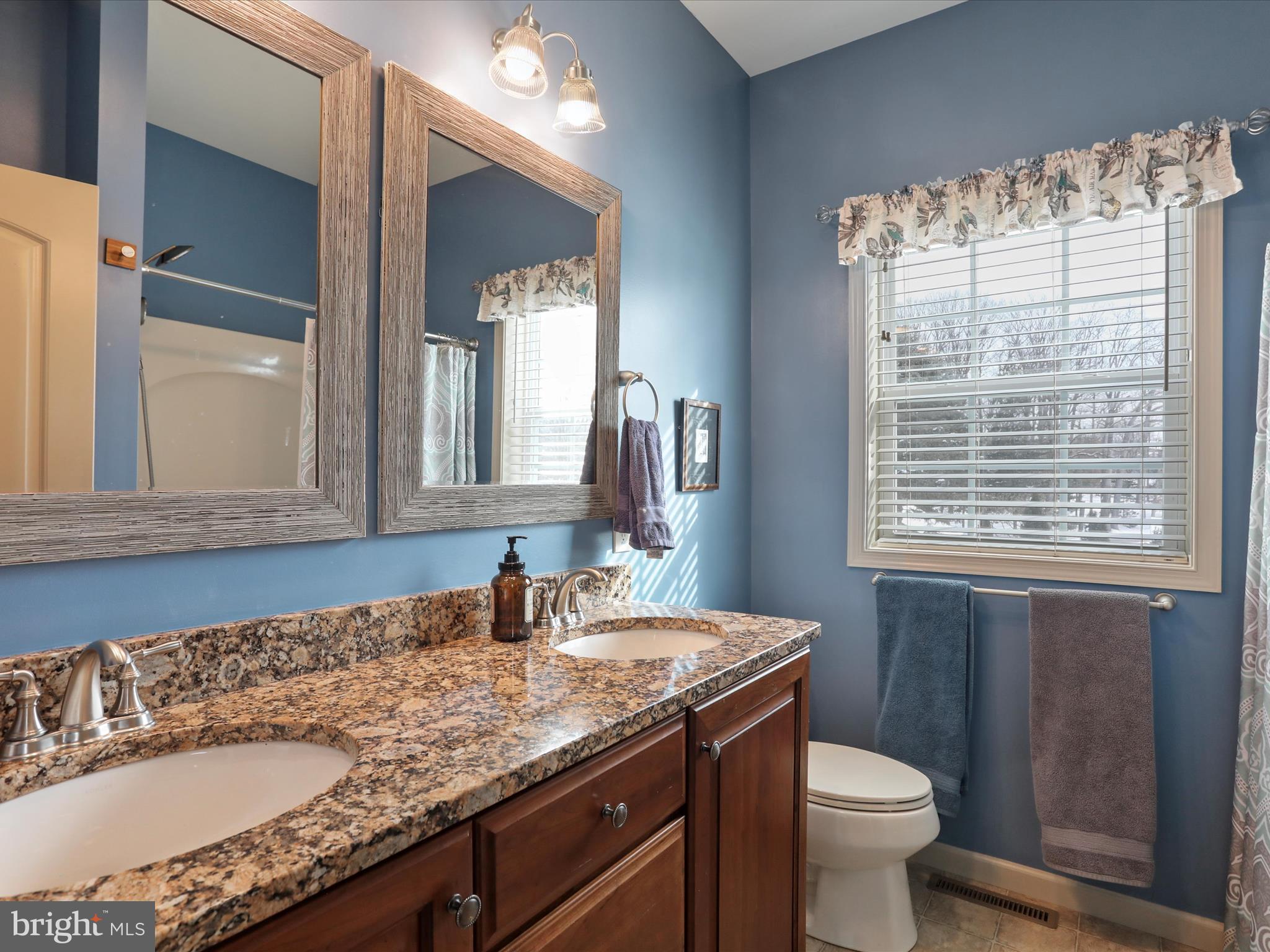 416 Castleton Drive Chambersburg, PA 17202 - Photo 27 of 51 a bathroom with a granite countertop sink a toilet and a mirror