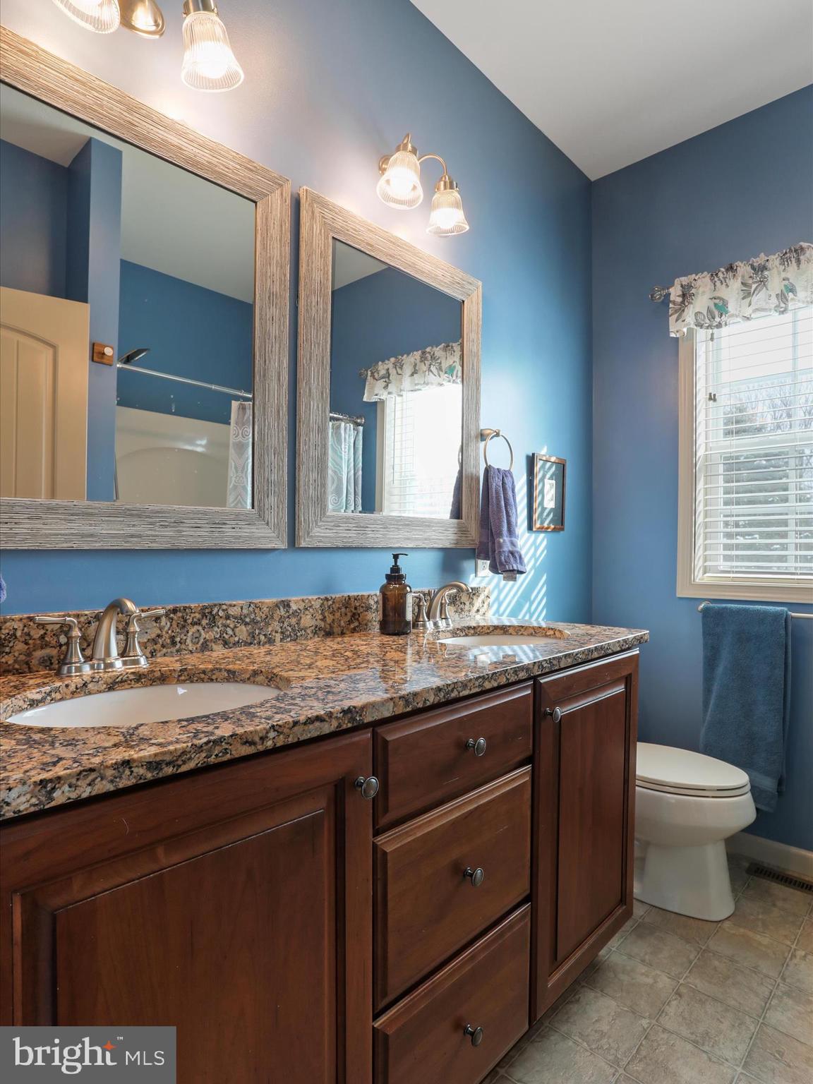 416 Castleton Drive Chambersburg, PA 17202 - Photo 28 of 51 a bathroom with a granite countertop sink a toilet and a mirror