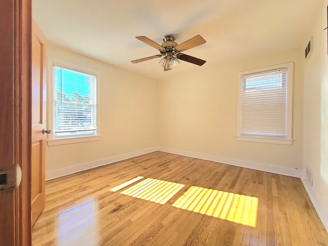 a view of a room with wooden floor and windows