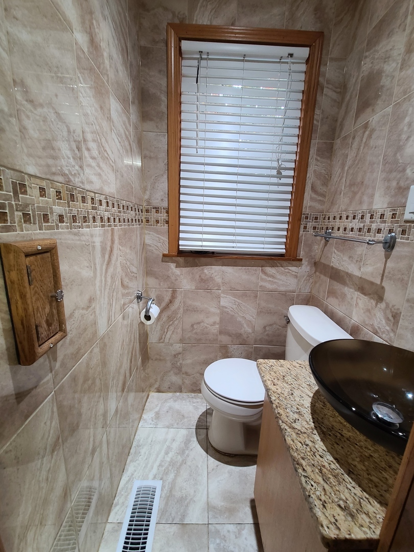 3801 West 63rd Place Chicago, IL 60629 - Photo 36 of 36 a bathroom with a toilet and a bathtub