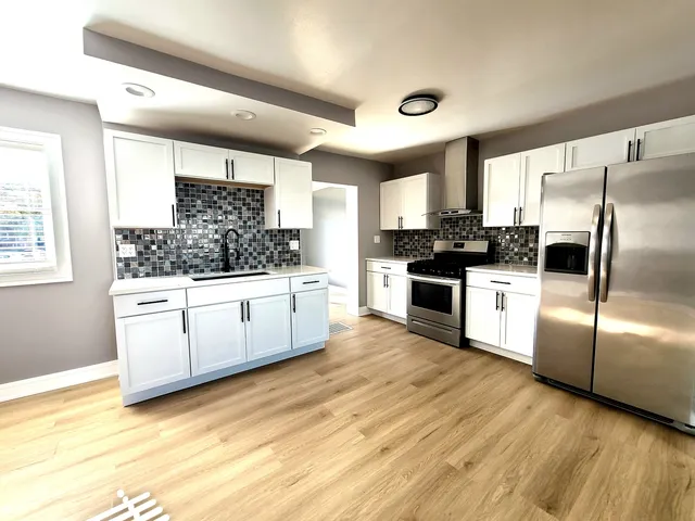 a kitchen with white cabinets and white appliances