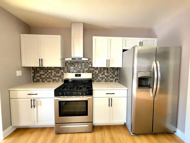 a kitchen with stainless steel appliances granite countertop a stove a refrigerator and a microwave