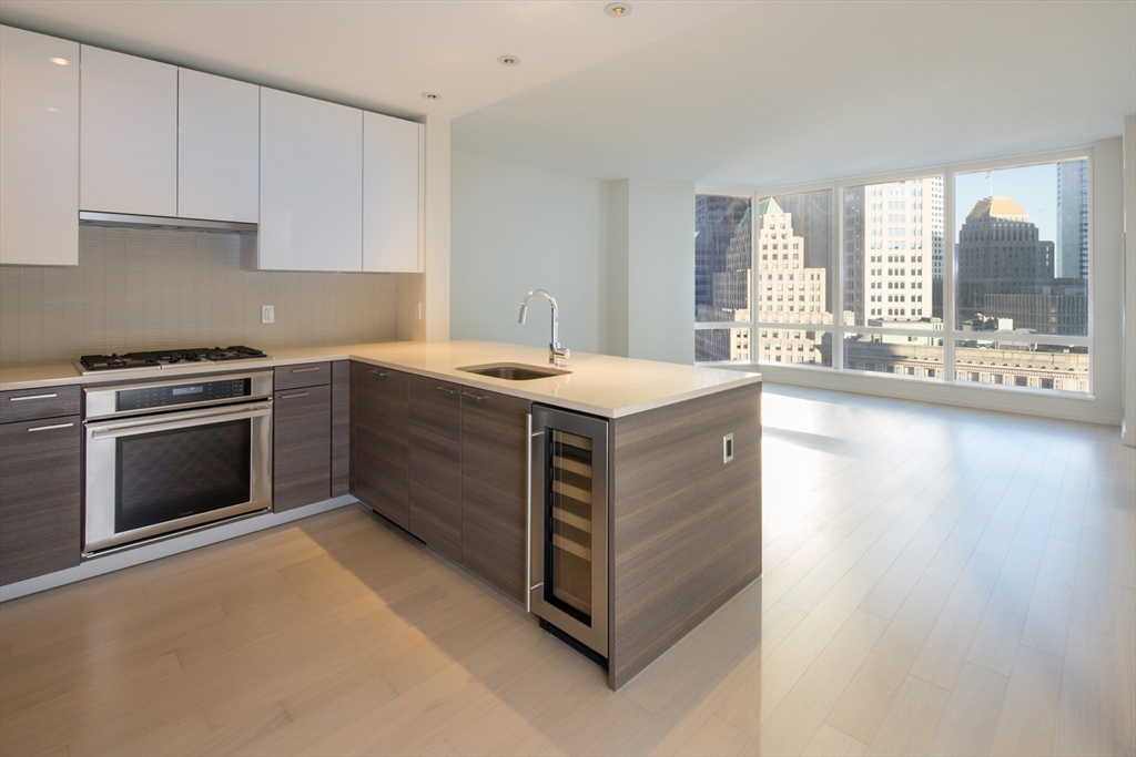 1 Franklin Street, Unit 1709 Boston, MA 02110 - Photo 1 of 17 a kitchen with a stove sink and cabinets