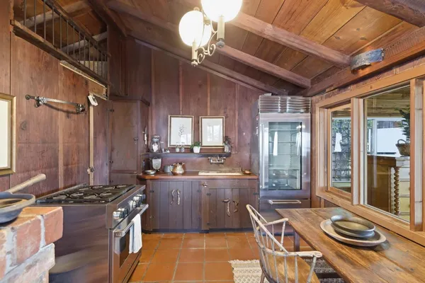 a kitchen with sink a stove and chairs