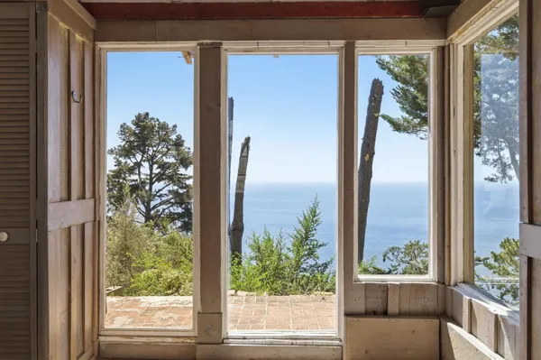 a view of a room that has a large window and front door