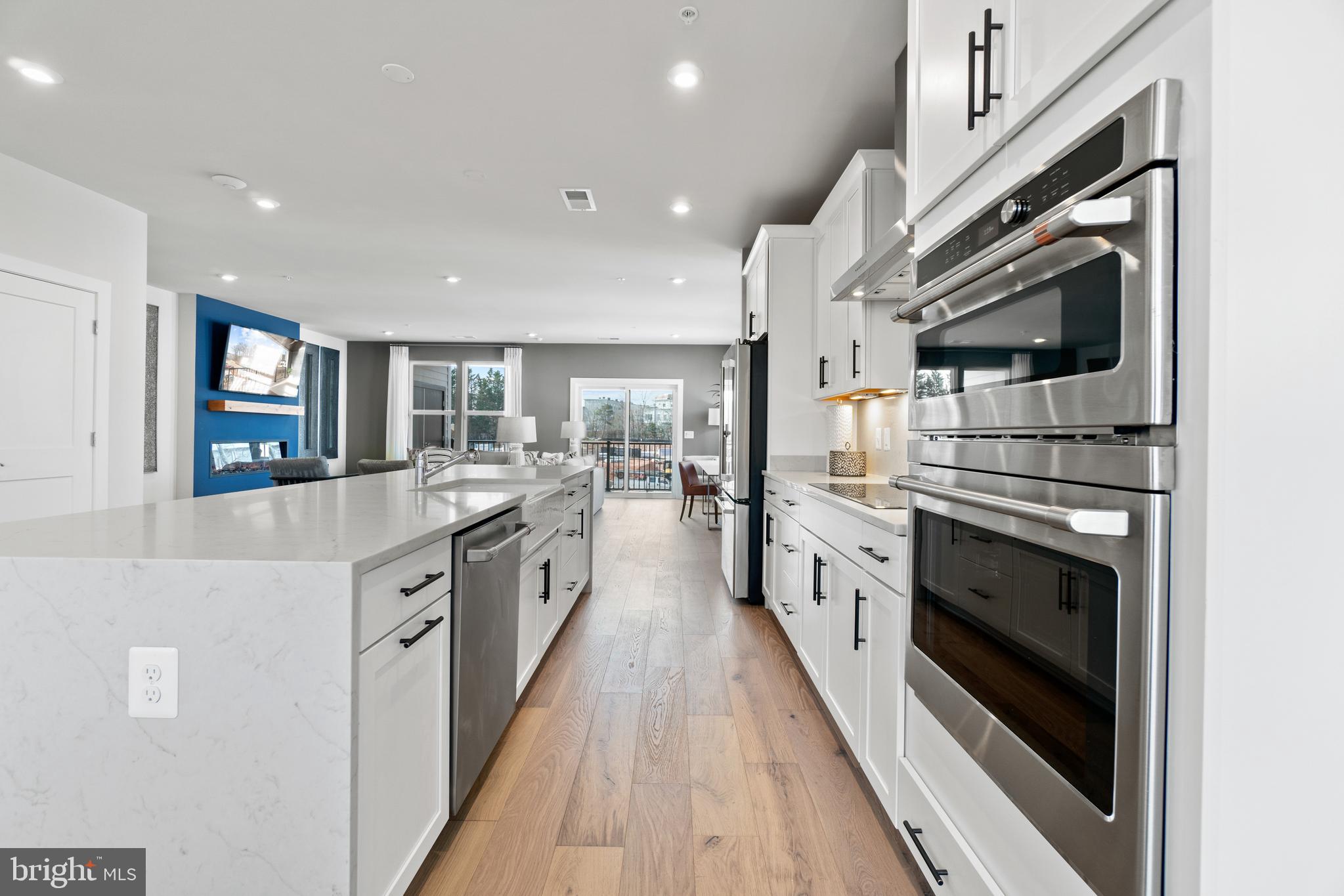 a white kitchen with stainless steel appliances granite countertop lots of counter top space and cabinets