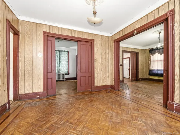 a view of a hallway with wooden floor and a living room