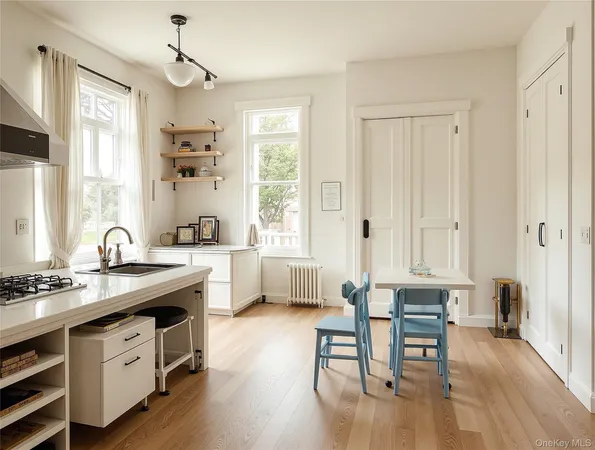 a kitchen with stainless steel appliances granite countertop a stove a sink dishwasher a dining table and chairs with wooden floor