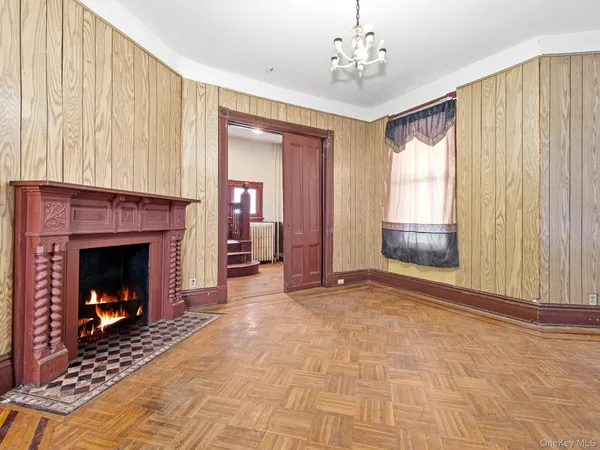 a view of an empty room with fireplace and a window