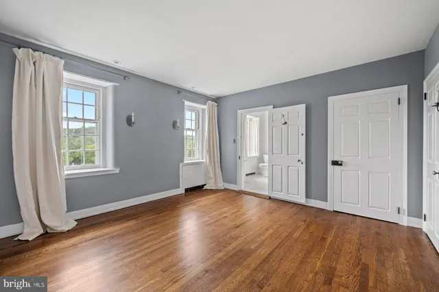 a view of empty room with wooden floor and fireplace