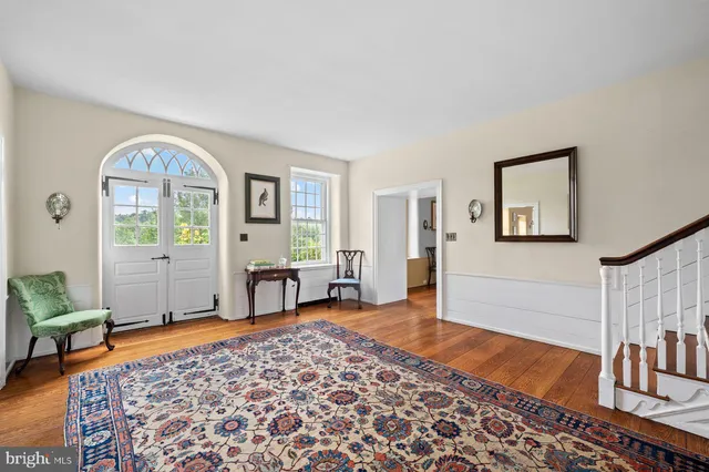 a spacious bedroom with a rug and a chandelier