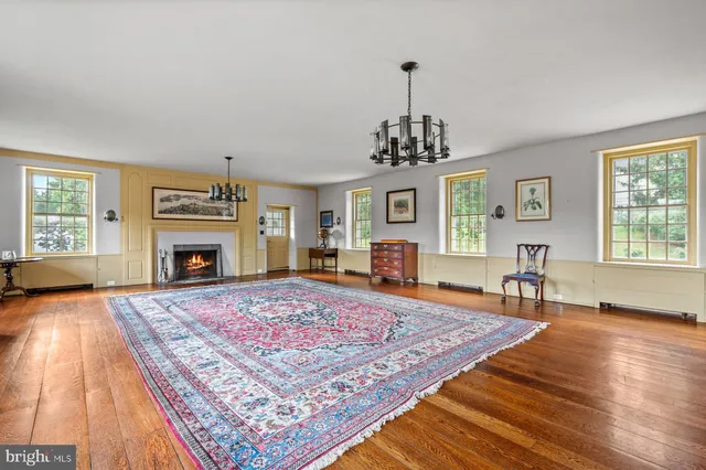 a view of a livingroom with a fireplace window and wooden floor