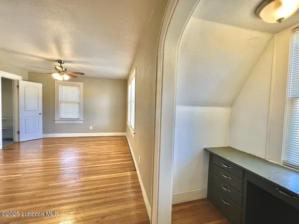 a view of an empty room with wooden floor