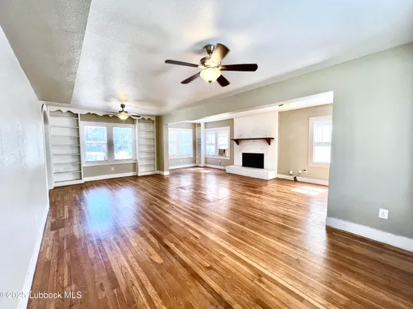 a view of a room with wooden floor and ceiling fan