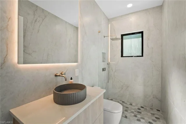 a bathroom with a sink a toilet and shower