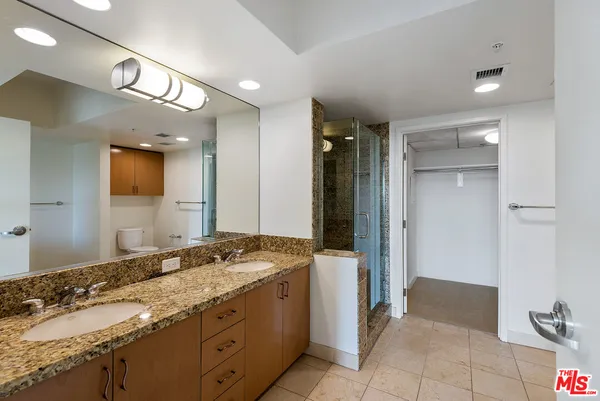a spacious bathroom with a granite countertop sink and a mirror