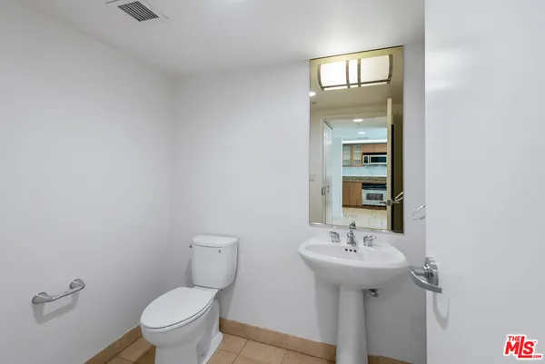 a bathroom with a sink toilet and mirror