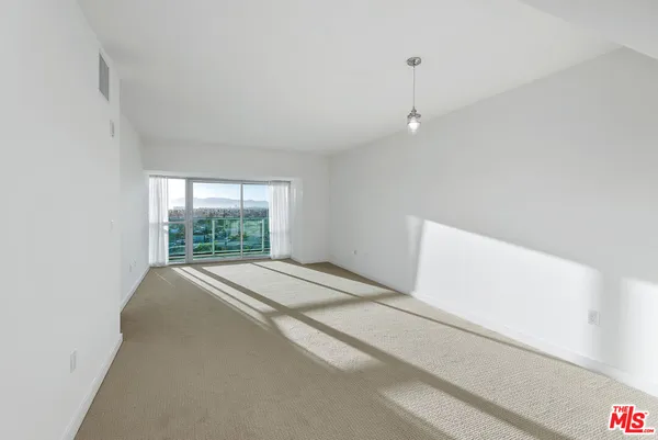 a view of a livingroom with an empty space and a window