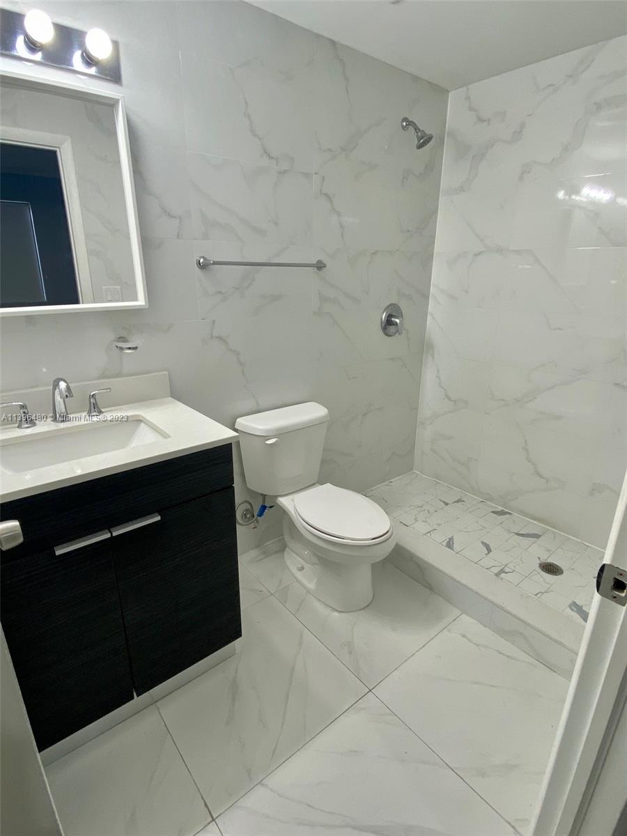 423 East 27th Street, Unit 101 Hialeah, FL 33013 - Photo 7 of 9 a bathroom with a sink a toilet a mirror and shower