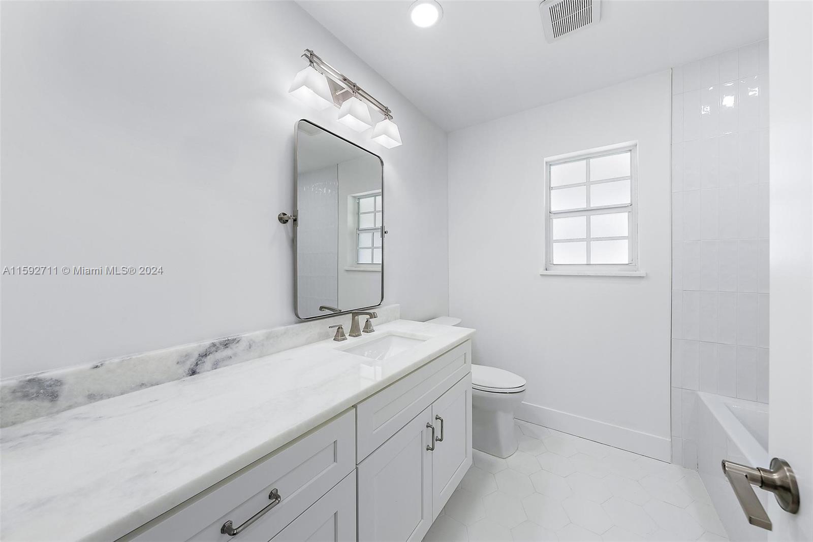 8547 Southeast Merritt Way Jupiter, FL 33458 - Photo 14 of 27 a bathroom with a sink a toilet and a mirror