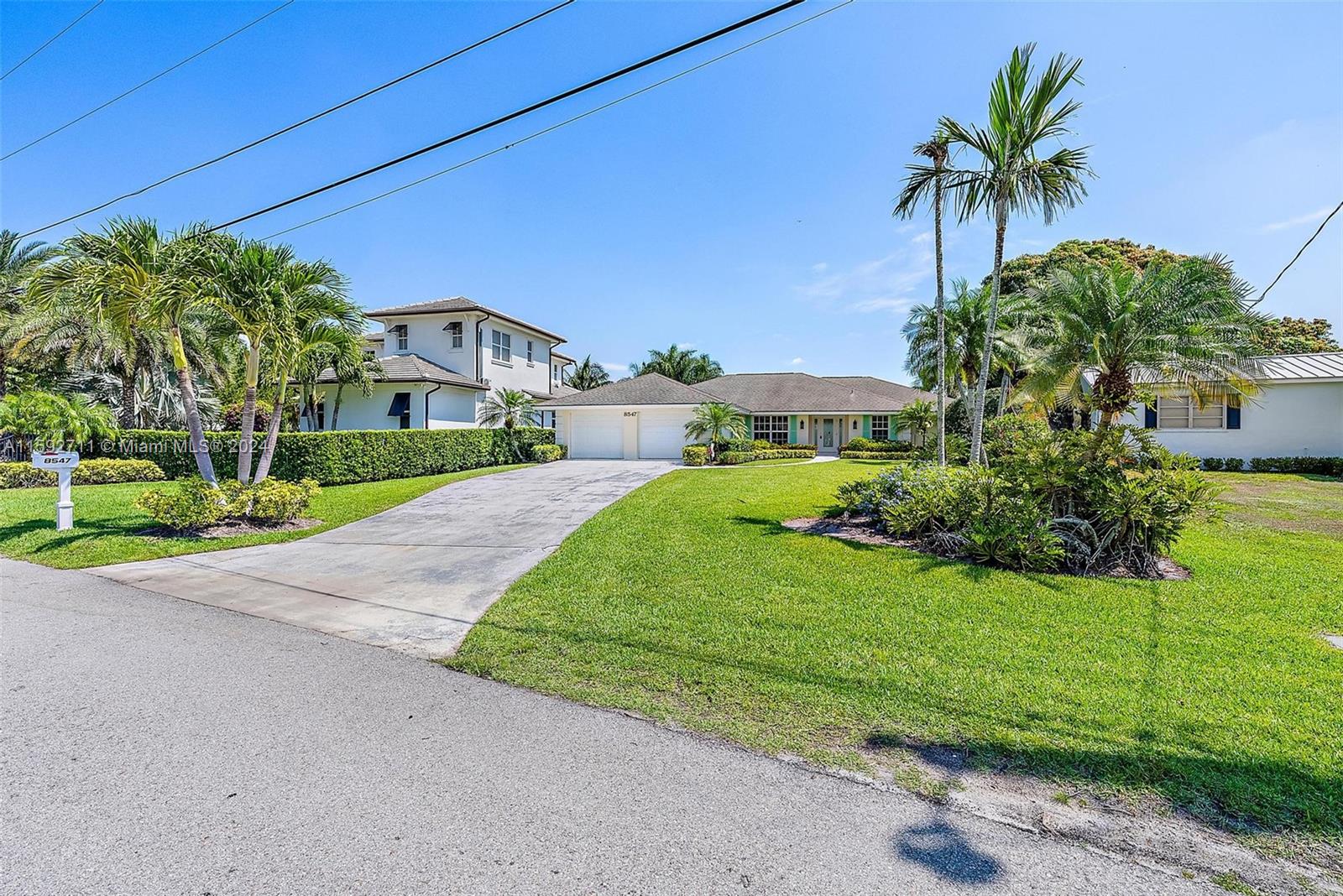 8547 Southeast Merritt Way Jupiter, FL 33458 - Photo 18 of 27 a front view of a house with a yard and garage
