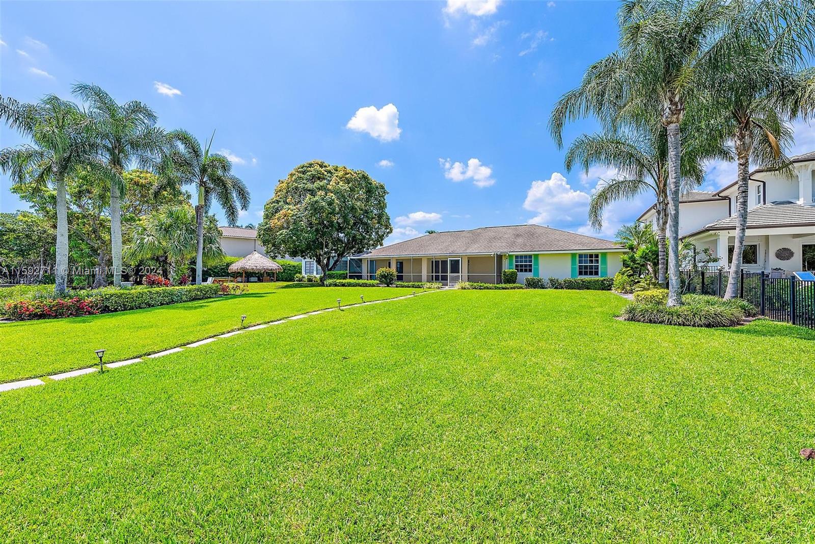 8547 Southeast Merritt Way Jupiter, FL 33458 - Photo 20 of 27 a view of a house with a big yard and palm trees
