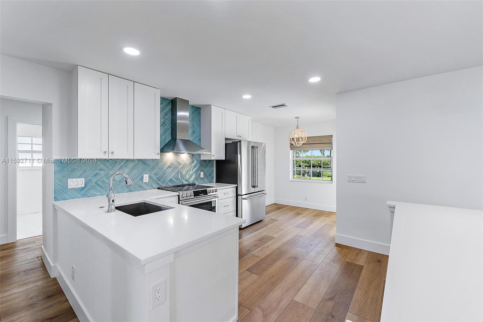 8547 Southeast Merritt Way Jupiter, FL 33458 - Photo 4 of 27 a kitchen that has a sink a stove and wooden floor