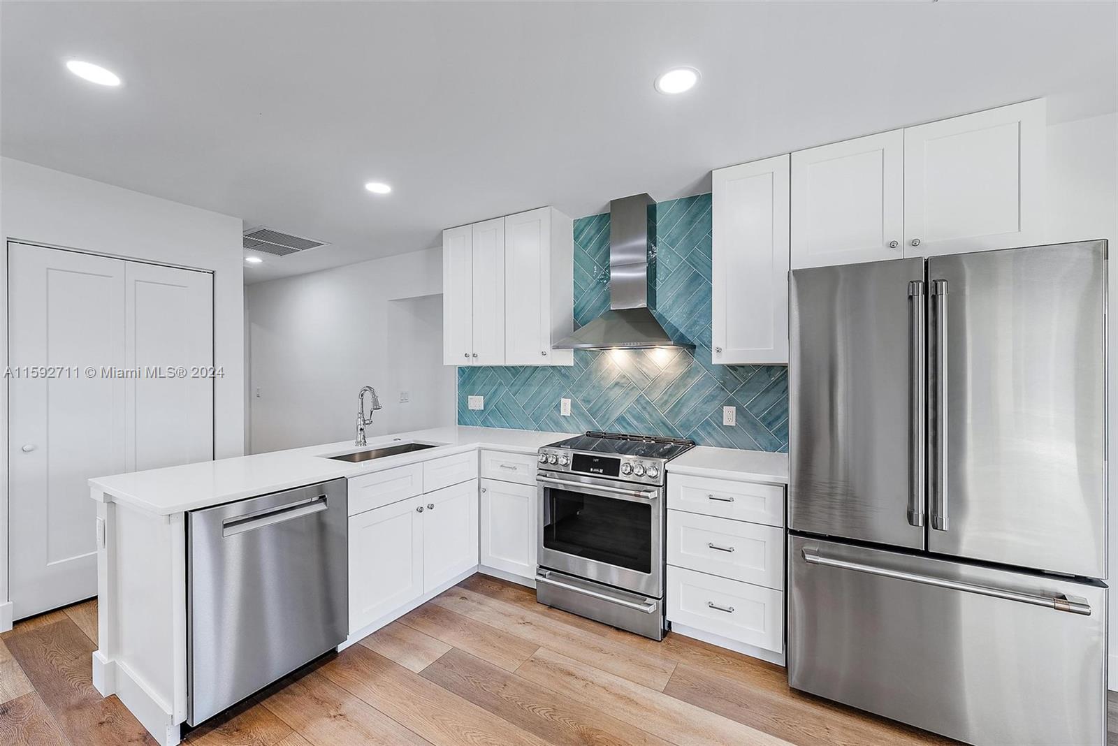 8547 Southeast Merritt Way Jupiter, FL 33458 - Photo 5 of 27 a kitchen with white cabinets and stainless steel appliances