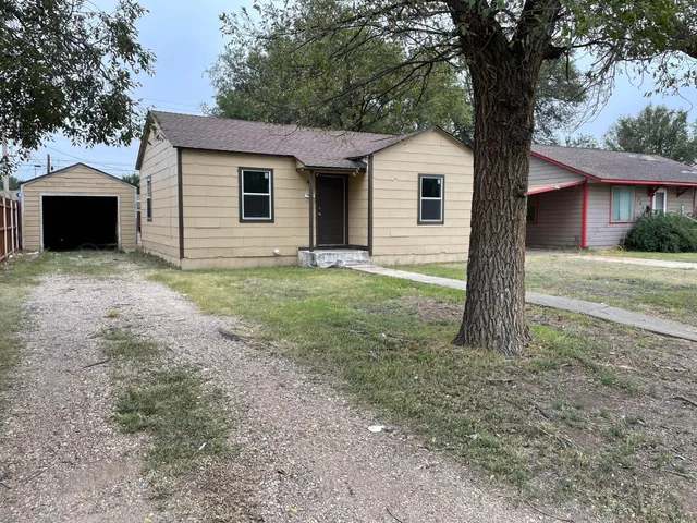 a front view of house with yard and trees