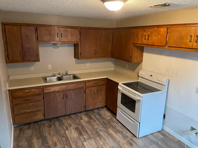 a kitchen with wooden cabinets and white appliances