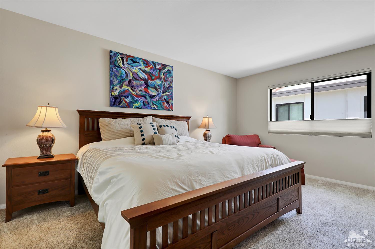 71 Calle Encinitas Rancho Mirage, CA 92270 - Photo 11 of 24 a bedroom with a bed a painting on the wall and a baby crib
