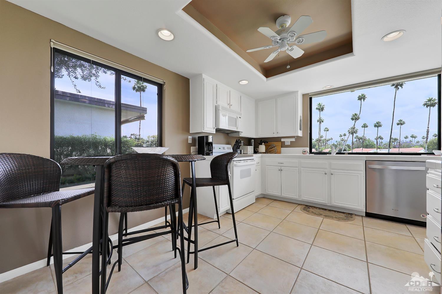 71 Calle Encinitas Rancho Mirage, CA 92270 - Photo 5 of 24 a kitchen with a dining table chairs cabinets and stainless steel appliances