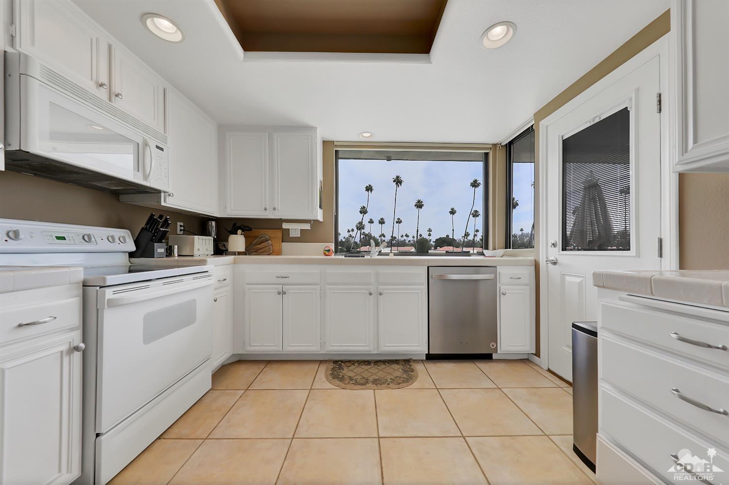 71 Calle Encinitas Rancho Mirage, CA 92270 - Photo 6 of 24 a kitchen with white cabinets a sink and white appliances