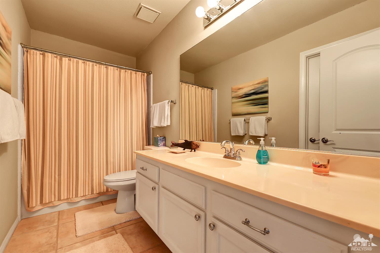 71 Calle Encinitas Rancho Mirage, CA 92270 - Photo 9 of 24 a bathroom with a double vanity sink toilet and a mirror