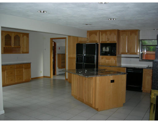 19 Edith Road Framingham, MA 01701 - Photo 2 of 10 a kitchen with stainless steel appliances kitchen island granite countertop a refrigerator a stove and a sink with wooden floor