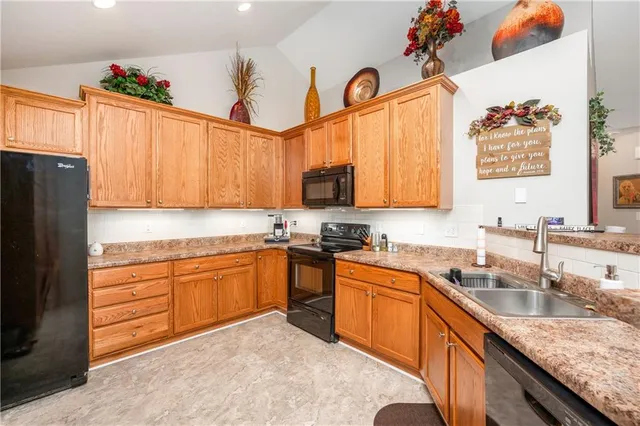 a kitchen with granite countertop a sink stainless steel appliances and cabinets