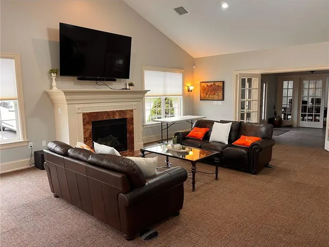 a living room with furniture a flat screen tv and a fireplace