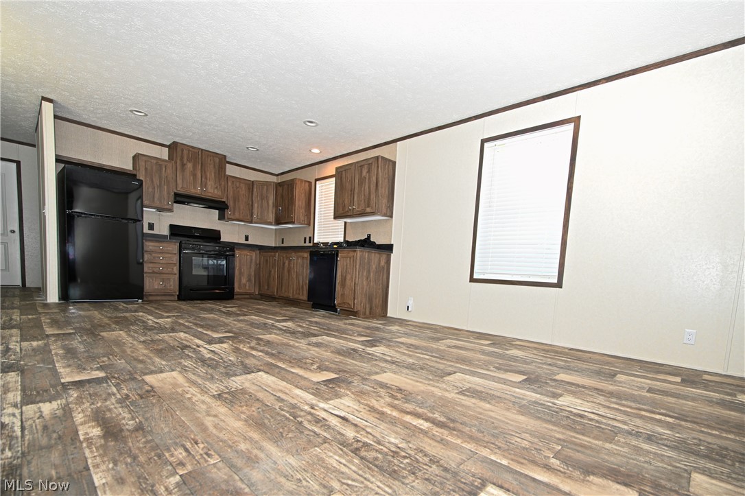 4534 Lake Road East, Unit 71 Geneva, OH 44041 - Photo 8 of 26 Kitchen with black appliances, dark hardwood / wood-style flooring, a textured ceiling, and crown molding