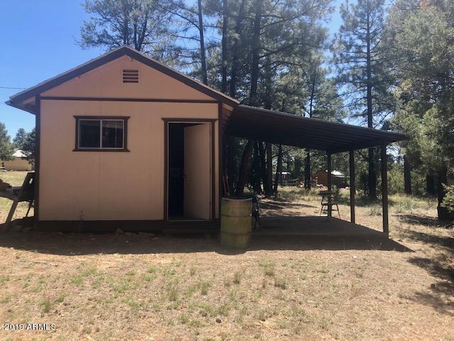3031 Ponderosa Road Overgaard, AZ 85933 - Photo 20 of 21 a front view of a house with a yard and seating space