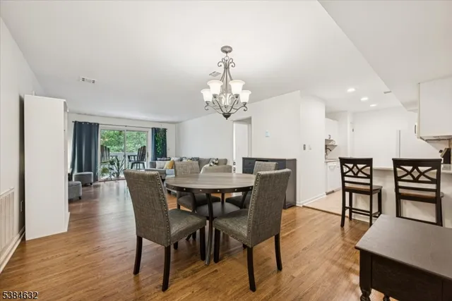 a dining room with furniture a chandelier and wooden floor