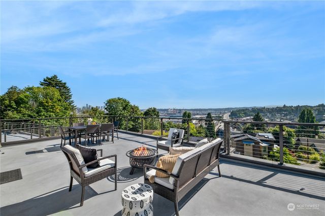 a view of a roof deck with couches and wooden floor