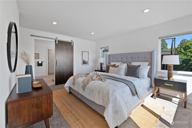 a spacious bedroom with a bed a couch and a potted plant