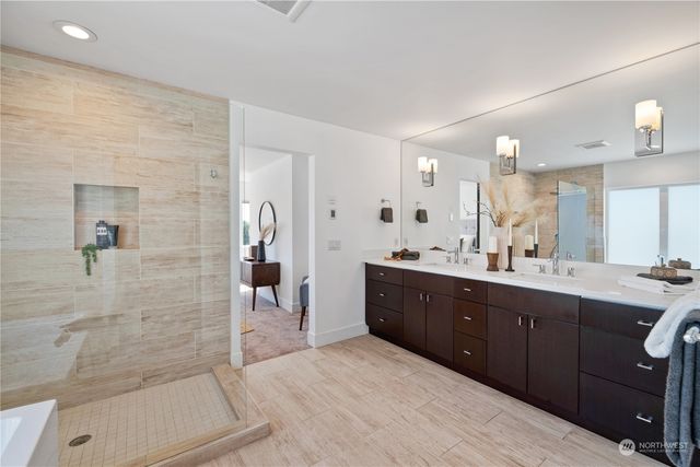 a large bathroom with a double vanity sink a large mirror and shower