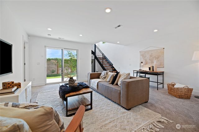 a living room with furniture flat screen tv and a large window