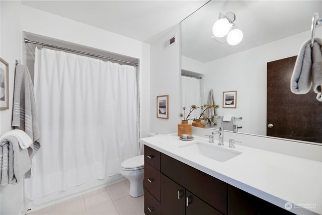 a bathroom with a double vanity sink toilet and a mirror