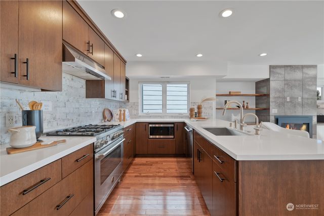 a large kitchen with stainless steel appliances granite countertop a sink stove and refrigerator