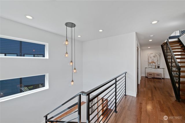 a view of a hallway with stairs to wooden floor